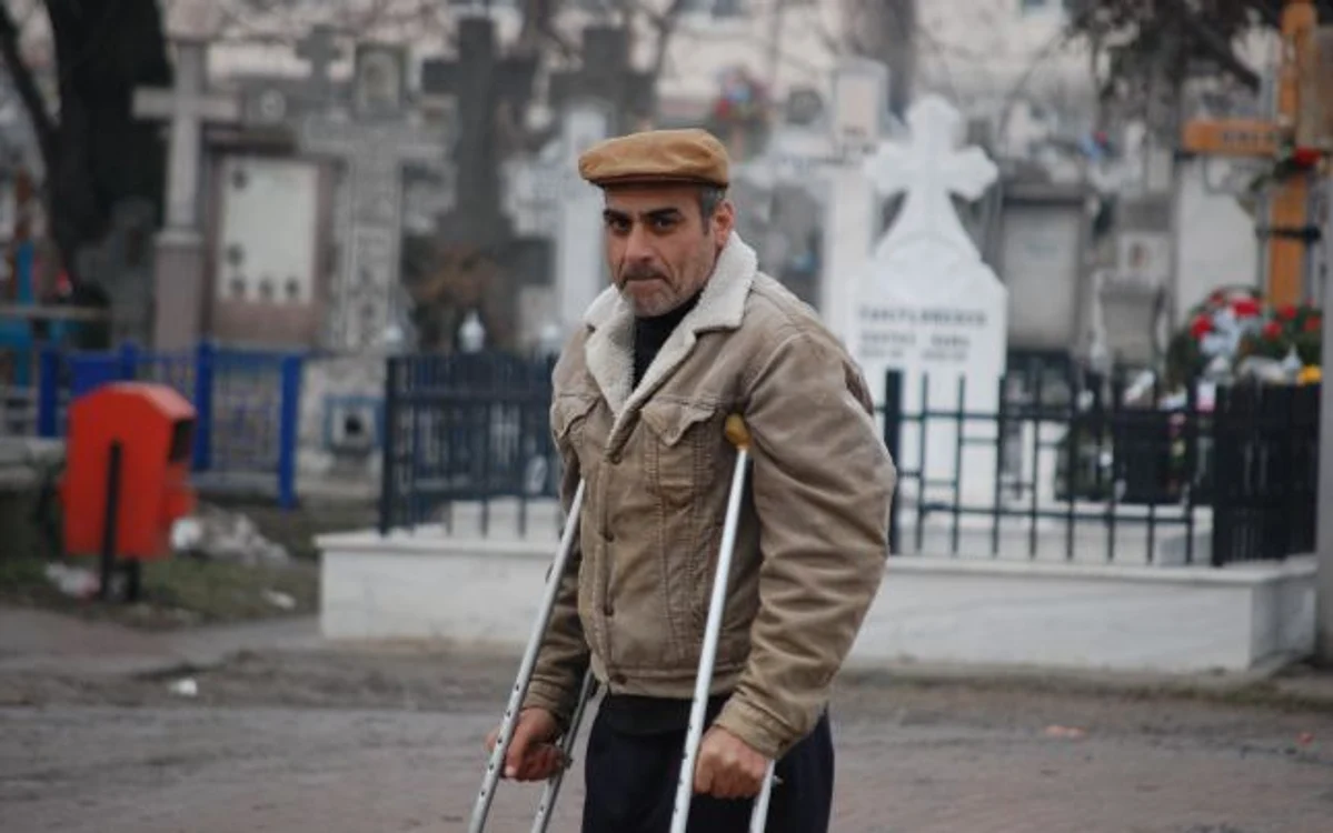 Ion se plimbă în cârje prin cimitirul Eternitatea pentru a-şi hrăni copiii