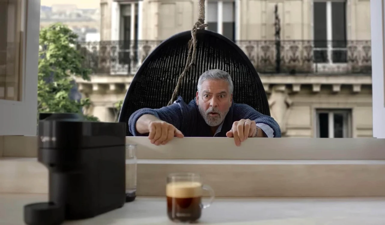 Actorul George Clooney escaladând geamul în reclama la Nespresso