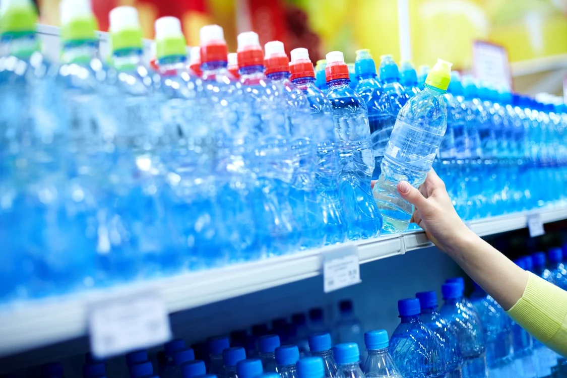 9331615   close up of female choosing good mineral water in a shop jpeg