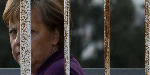 Cancelarul german Angela Merkel trece pe lângă uşa unui hotel desfiinţat într-o zonă controlata de Naţiunile Unite în Nicosia Cipru ianuarie 2011 FOTO AP