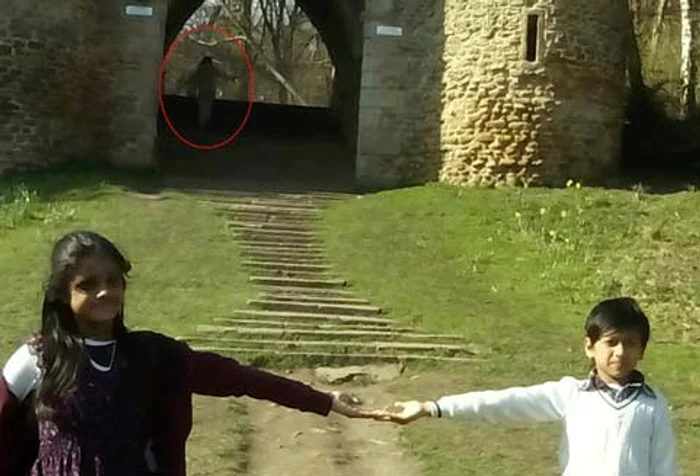 În spatele celor doi micuţi apare o siluetă stranie 