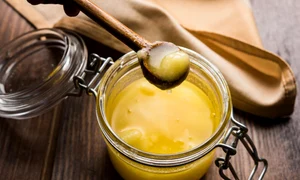 ghee butter in glass jar with wooden spoon jpg