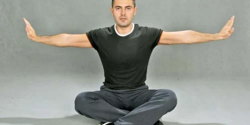 Stai turceşte, cu picioarele încrucişate şi cu braţele perfect întinse lateral.