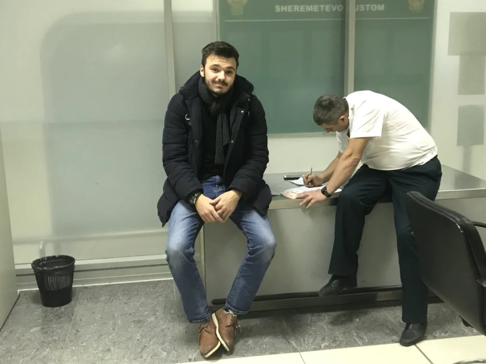 Ruslan Şaveddinov îşi salută colegii în timp ce este reţinut pe Aeroportul Şeremetievo FOTO Twitter @Kira_Yarmysh