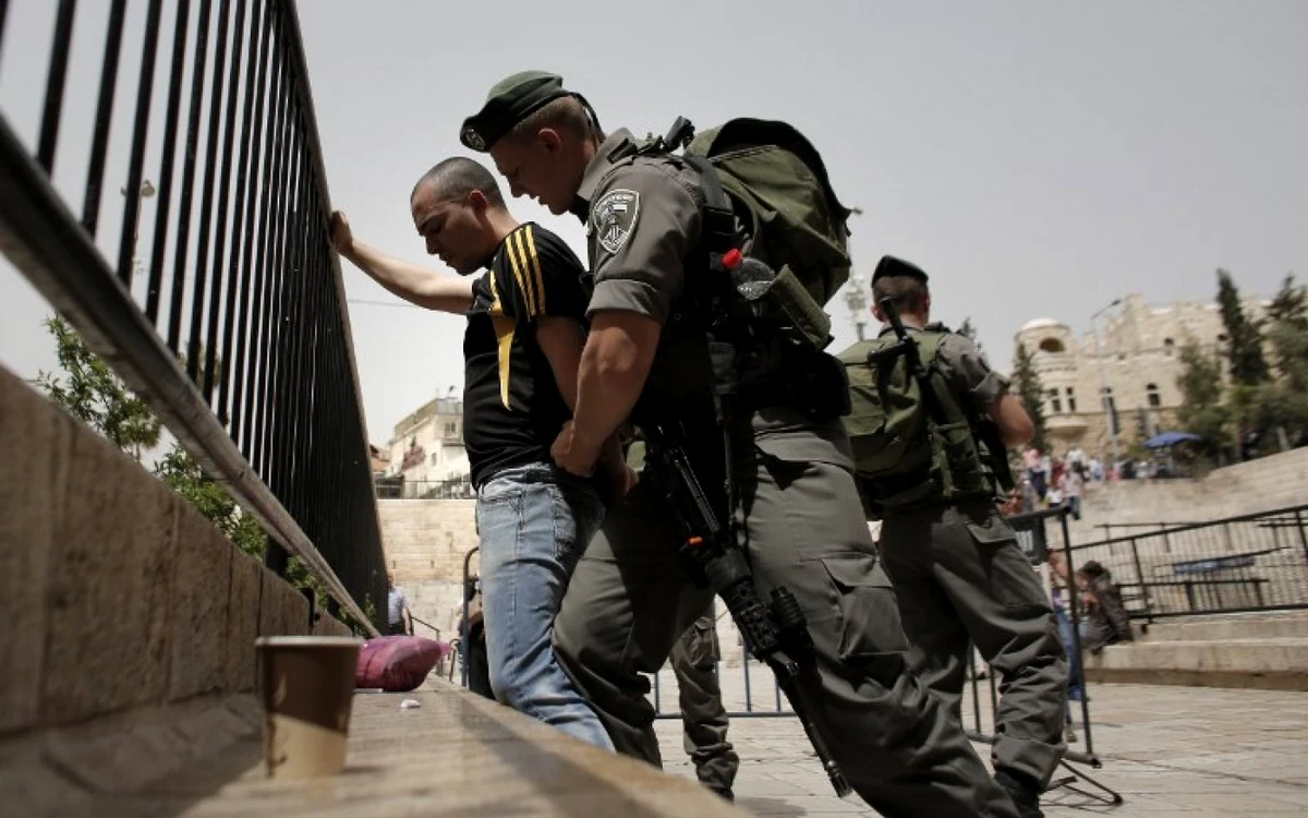 Un poliţist de frontieră israelian percheziţionează un palestinian 
la Poarta Damascului, intrarea principală în vechiul Ierusalim FOTO AFP