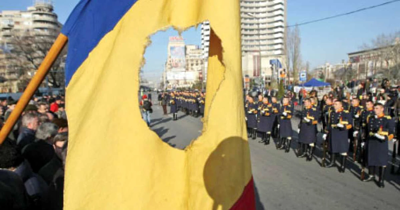 21 decembrie 2010: revoluţionari abătuţi, tricolorul fără stemă şi militari din garda naţională dând onorul