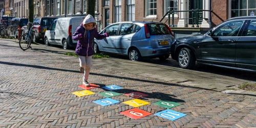 Fetita care se joaca pe o stradă în Amsterdam, Olanda FOTO Shutterstock 