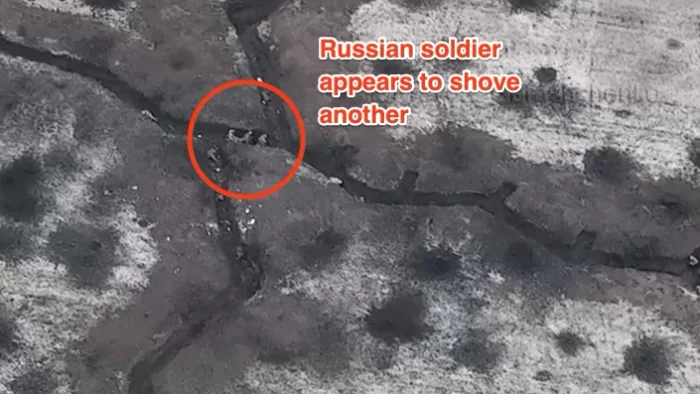 Un soldat identificat ca fiind rus pare să împingă un camarad mai aproape de trupele ucrainene