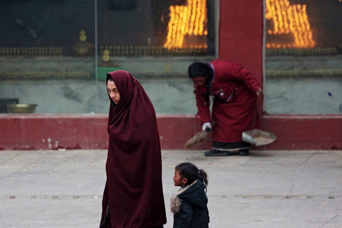 Călugăr tibetan din Larung Gar, alături de o fetiță