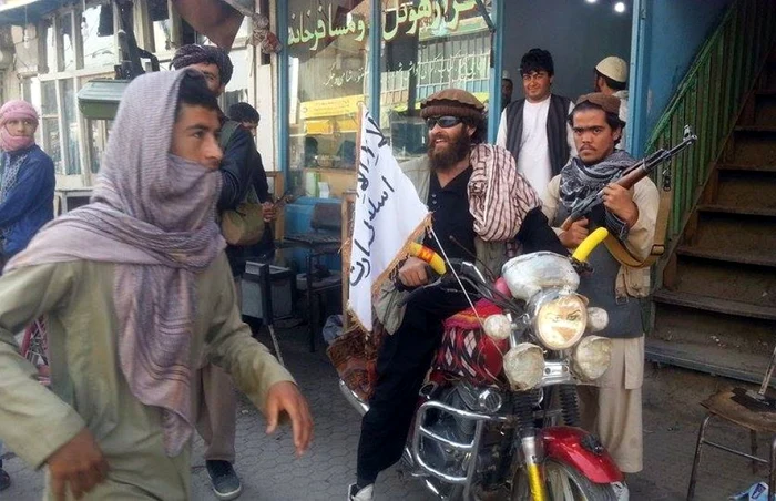 Un luptător stă pe motocicleta în care e înfipt un steag Taliban pe o stradă din oraşul Kunduz Afganistan FOTO AP