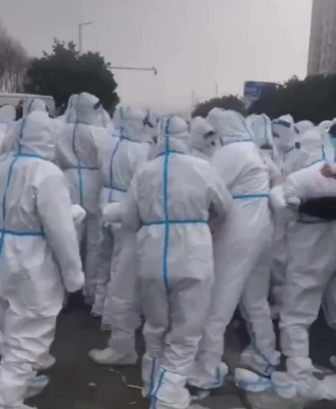 Oamenii îmbrăcați în combinezoane albe. Foto: Captură video Twitter