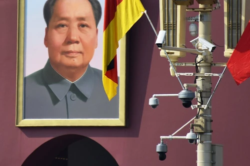 Camere de supraveghere pe un stâlp, în China, cu portretul lui Mao Zedong în fundal