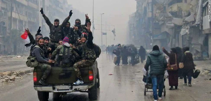 Luptători pro-Assad sărbătoresc victoria armatei siriene pe străzile din estul Alepului Sursă foto: CNN