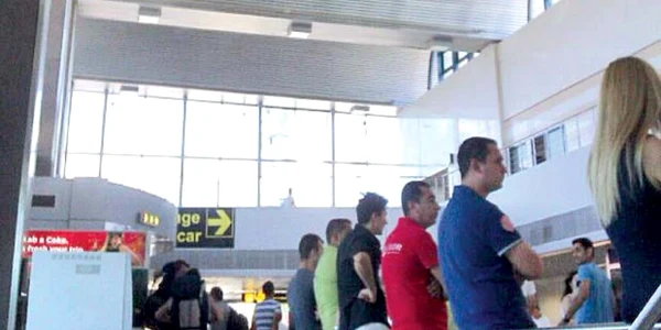 În incinta aeroportului, mai multe persoane aşteaptă posibili clienţi