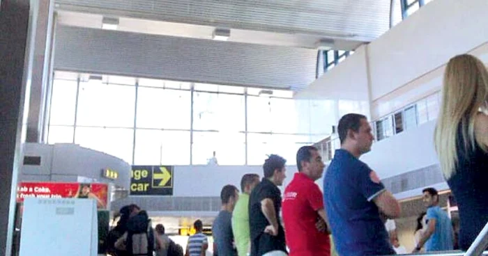 În incinta aeroportului, mai multe persoane aşteaptă posibili clienţi