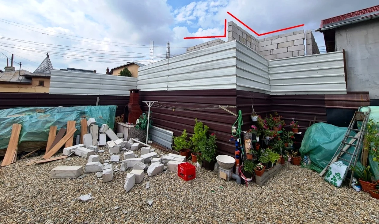 Bărbatul acuzat şi-a împins pereţii peste gardul vecinului. FOTO. C.S