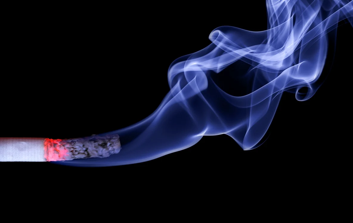 Prim plan cu o țigară aprinsă care scoate fum pe un fundal întunecat Foto Pixabay