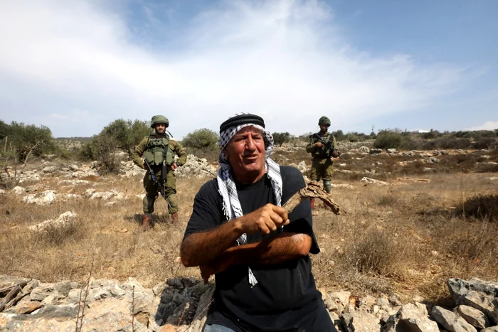 Soldați israelieni lângă un fermier palestinian în Cisiordania. Foto: Arhiva Adevărul