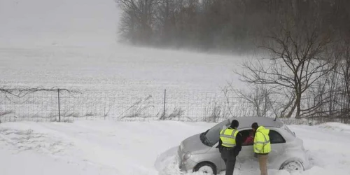 Salvatorii au venit sa ofere ajutor unei maşini care a derapat datorită căderilor masive de zăpadă în apropiere de Columbus