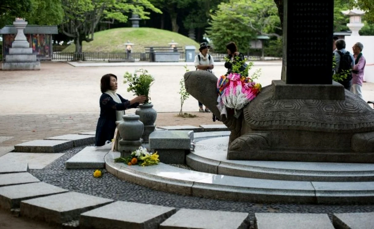 O femeie depune flori la memorialul victimelor de la HIROSHIMA FOTO AFP