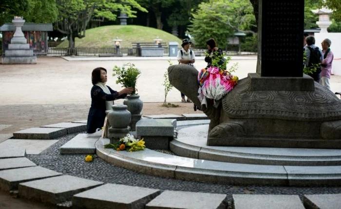 O femeie depune flori la memorialul victimelor de la HIROSHIMA FOTO AFP