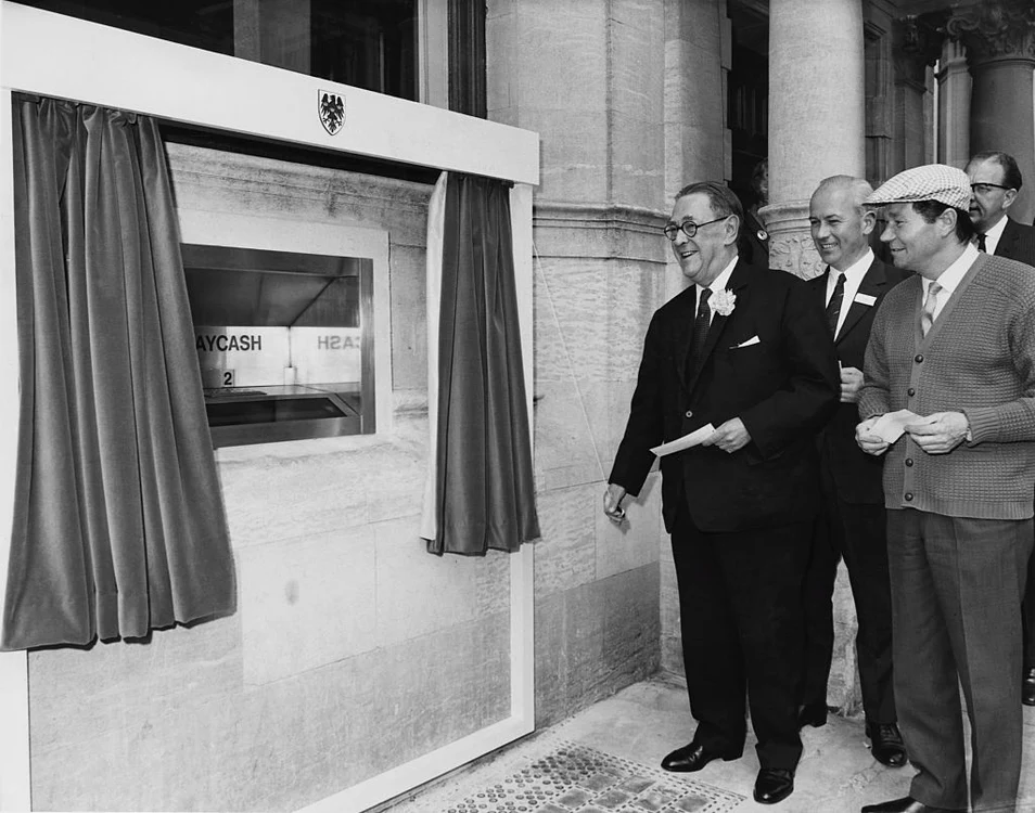 
    Actorul Reg Varney (în dreapta, cu șapcă), alături de oficiali ai Băncii Barclays, a inaugurat primul bancomat din lume, la 27 iunie 1967, în Londra, devenind primul om care a folosit un ATMFoto: Guliver/Getty Images  