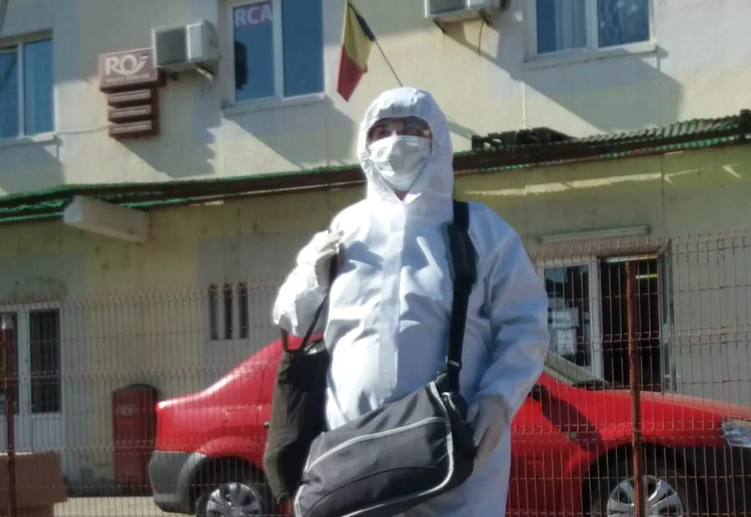 Poştaşul Monica Baci a îmbrăcat un costum de protecţie pentru a putea duce pensiile