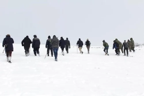 Oameni pe câmp în căutarea tânărului dispărut