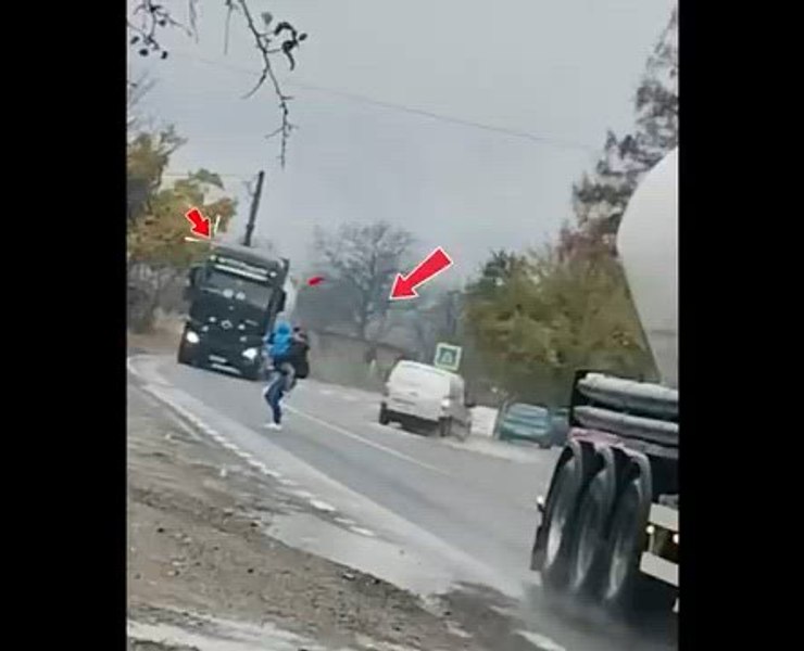 Gestul inconștient al unei mame cu copilul în brațe: trece grăbită printre TIR-uri, deși la câțiva pași există trecere pentru pietoni