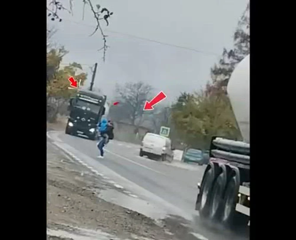 Gestul inconștient al unei mame cu copilul în brațe: trece grăbită printre TIR-uri, deși la câțiva pași există trecere pentru pietoni