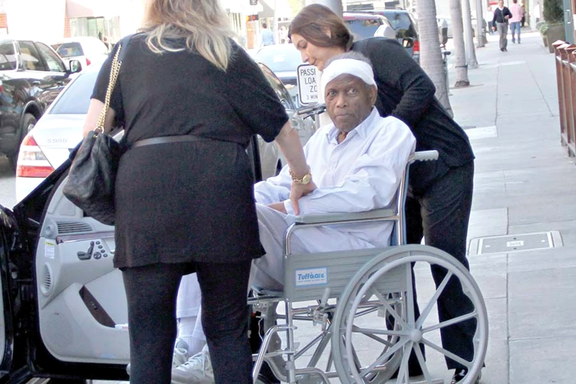 Starul părăseşte  o clinică  medicală  împreună cu  soţia sa, Joanna, (cu spatele) şi o asistentă (Fotografii: guliver/splashnews)