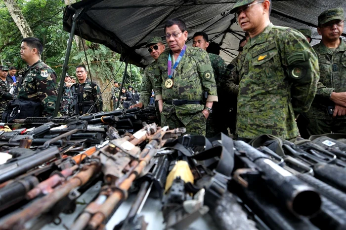 Preşedintele Rodrigo Duterte (centru) inspectează arme confiscate de la militanţi islamişti Foto: EPA