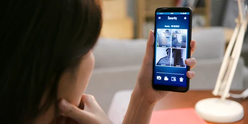 Femeie asiatică se uită pe telefon pe camerele de supraveghere FOTO Shutterstock