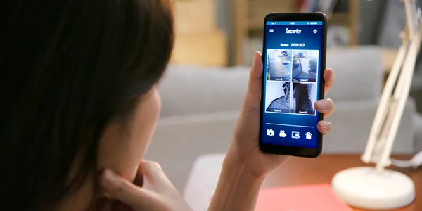 Femeie asiatică se uită pe telefon pe camerele de supraveghere FOTO Shutterstock 