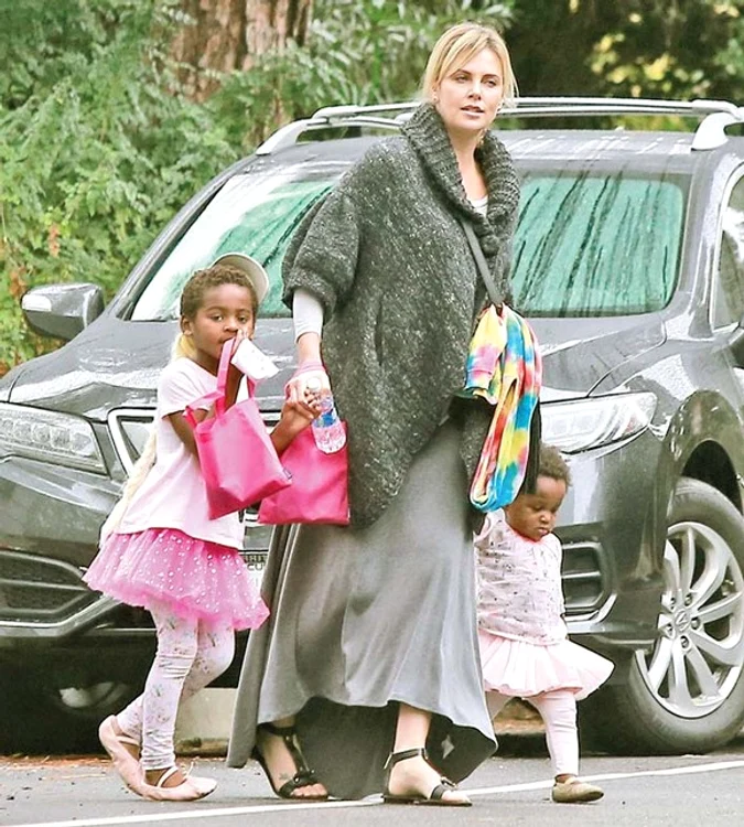 Charlize susține că „crește două fete”, pe Jackson și sora acestuia, August 