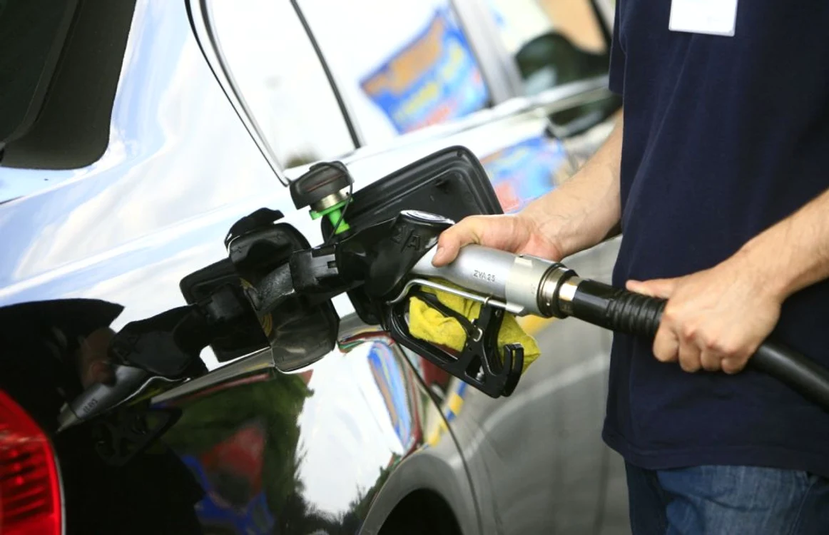 barbat care isi alimenteaza masina cu benzina
