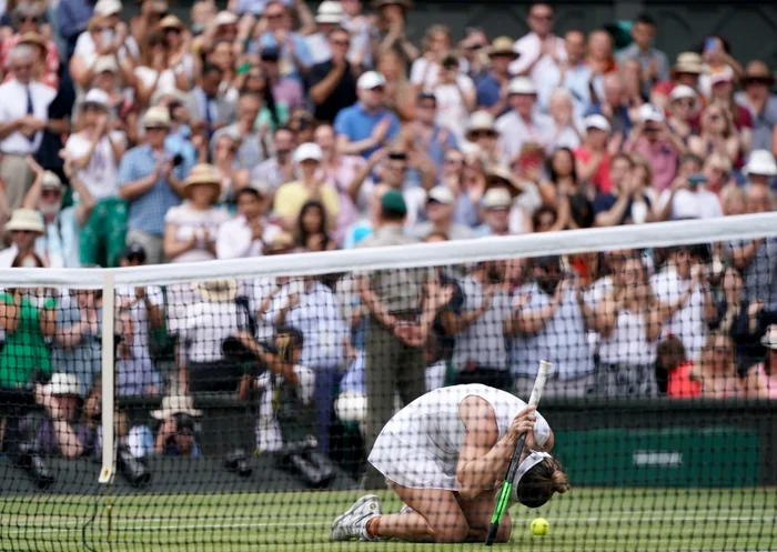 Simona Halep a îngenunchiat pe iarbă după ultimul punct al finalei cu Serena WilliamsFoto: EPA-EFE