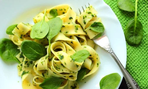 Tagliatelle pasta with spinach sauce and fresh leafs on a white plate jpeg