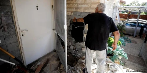Civil israelian în faţa unei case distruse de una din cele aproape 700 de rachete lansate din Gaza