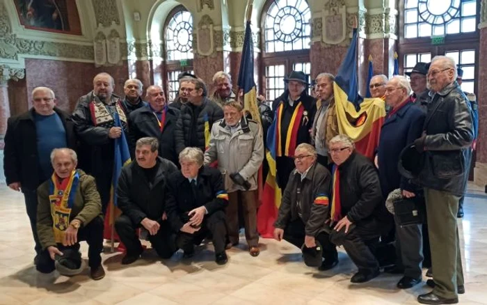 Revoluţionari cu steagul din Decembrie 1989 în Sala Unirii din Alba Iulia