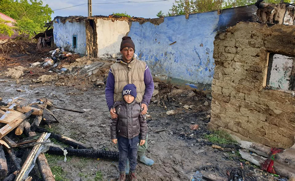 Alături de tată şi de ruinele căsuţei mistuite de flăcări 