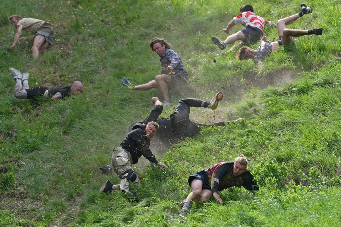 Imagine de la Cheese Rolling 2023, cu alergatorii cazant pe dealuri