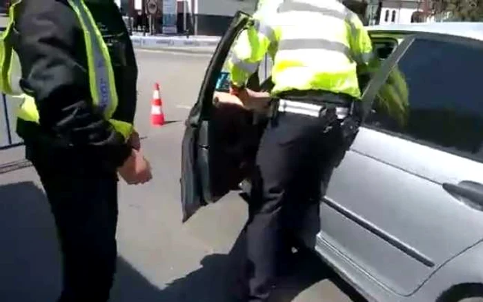 Poliţistul local încearcă să-l scoată cu forţa pe şofer din maşină FOTO: printscreen Youtube