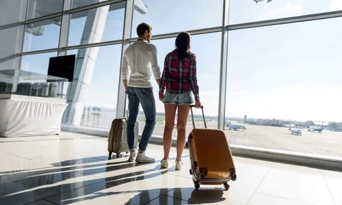 cuplu care pleaca in vacanta bagaje aeroport jpeg