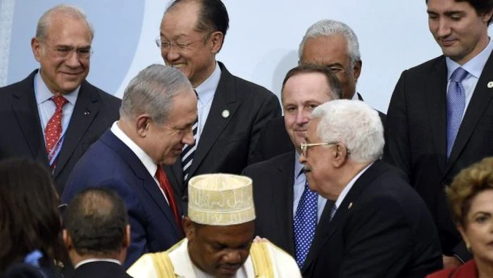 Strângere de mâini protocolară între premierul israelian Benjamin Netanyahu (stânga) şi preşedintele palestinian Mahmoud Abbas (dreapta) în marja summitului COP21 de la Paris FOTO AFP