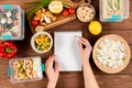 hands writing notebook with casseroles ad food jpg