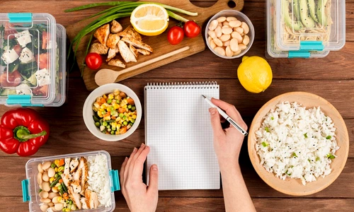 hands writing notebook with casseroles ad food jpg