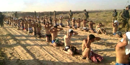 Soldaţi israelieni păzesc prizonieri palestinieni capturaţi în timpul ofensivei militare în Fâşia  Gaza FOTO Reuters 