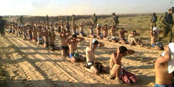 Soldaţi israelieni păzesc prizonieri palestinieni capturaţi în timpul ofensivei militare în Fâşia  Gaza FOTO Reuters 
