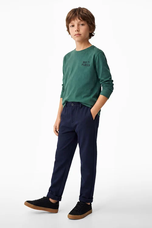 Băiat purtând pantaloni conici Koton cu manșete pliabile, pentru un look școlar elegant
